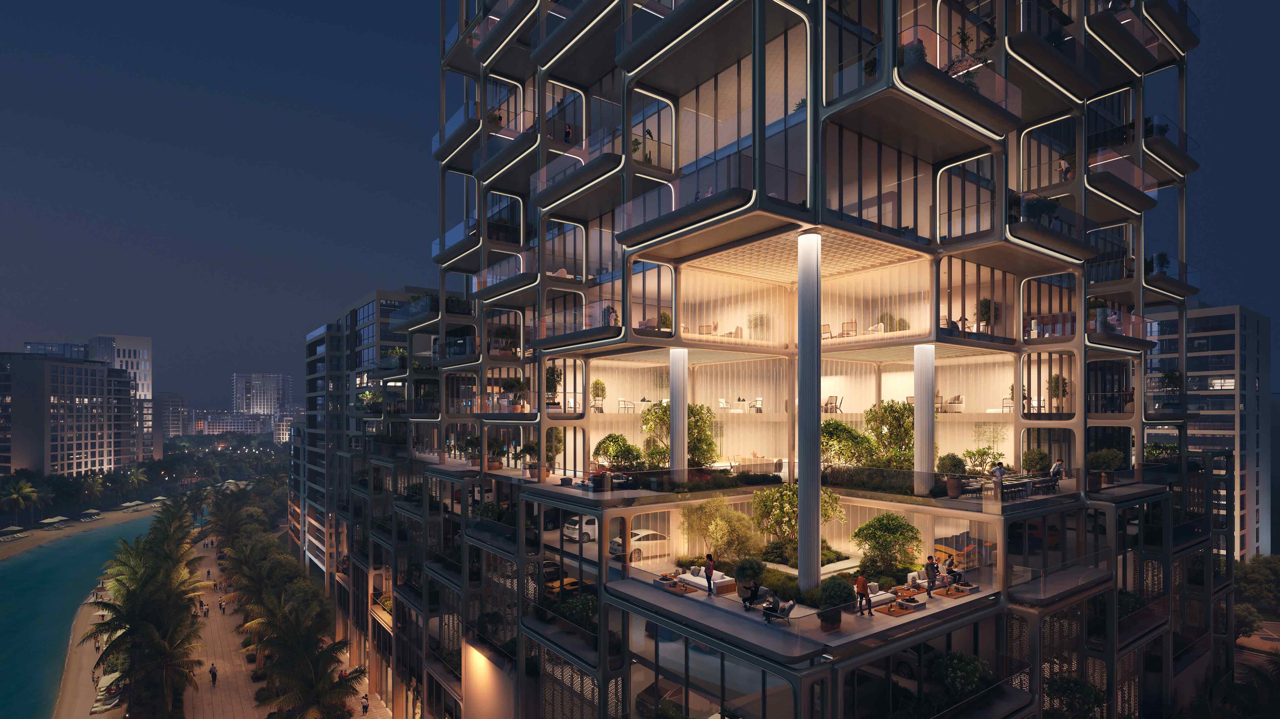 The Symphony By Imtiaz A modern, multi-story building with illuminated, open spaces and greenery, set against a nighttime city skyline.